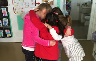 Gruppo di bambini che si abbracciano in cerchio