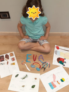 Bambina con vari disegni e creazioni fatte con la pasta modellabile