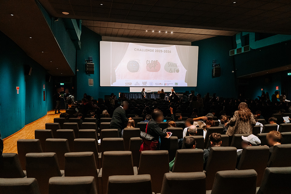 foto di teatro con numerose persone a sedere e sul palco