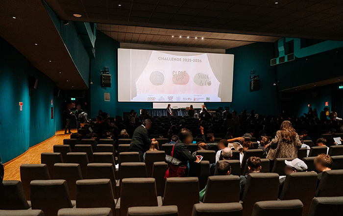 foto di teatro con numerose persone a sedere e sul palco